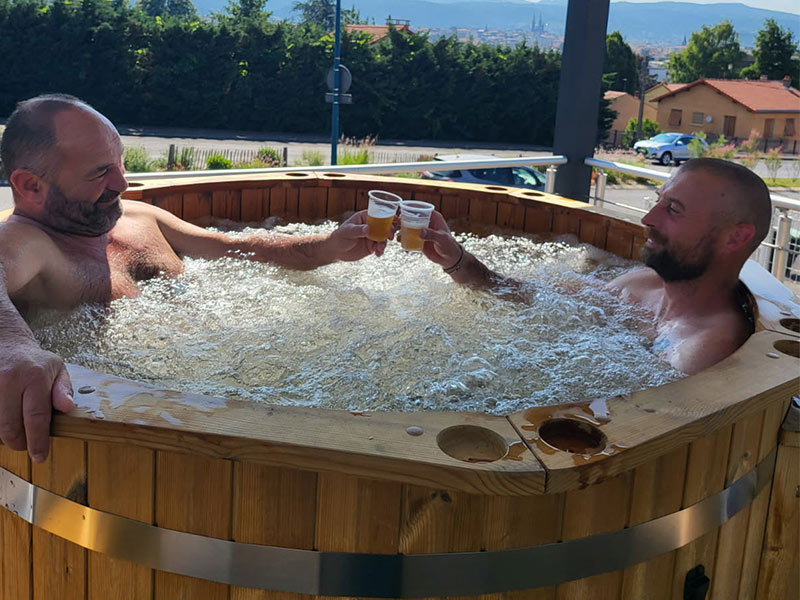 Deux hommes trinquent dans un bain nordique