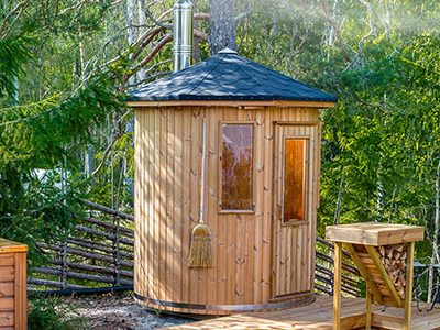 Sauna tonneau avec cheminée dans un jardin