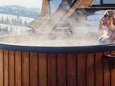 Femme dans bain nordique proche d'un chalet